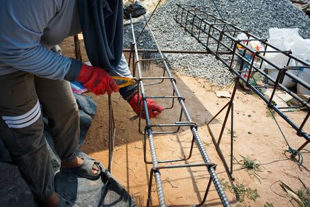 Worker doing the steelwork for reinforcement of the concrete structure at the construction siteの写真素材