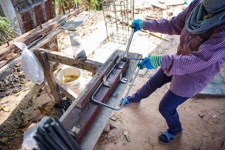 Worker doing the steelwork for reinforcement of the concrete structure at the construction siteの写真素材