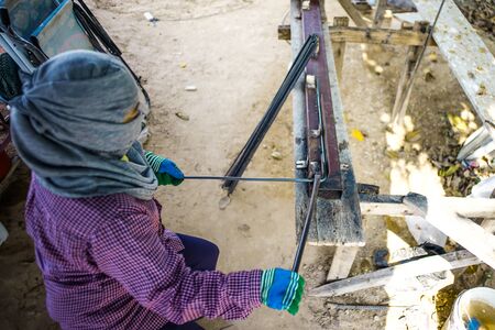 Worker doing the steelwork for reinforcement of the concrete structure at the construction siteの写真素材