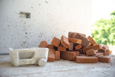 Closeup picture of red bricks pile and tools at the house under constructionの写真素材
