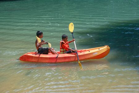 Ko Lanta Krabi, Thailand : October 20, 2019 - Boys are kayaking  in the sea at Ko Lanta at the south of Thailand. Brothers play on a canoe in sunny day. Lifestyle of happy brotherhoodのeditorial素材