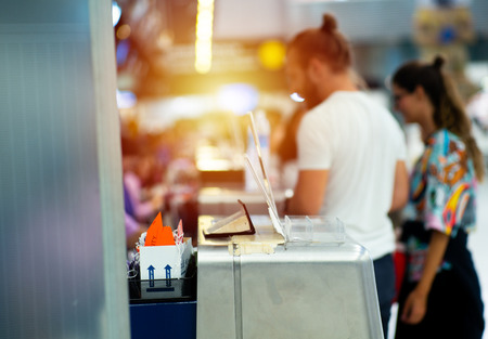 Selective focus on metal counter of airline at the airport with defocused passengers checking-in background.のeditorial素材