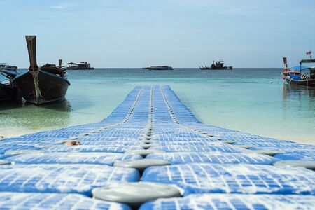 Crowd of boats floating on the sea with defocused buoys in foreground in sunny dayの写真素材