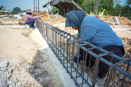 Worker doing the steelwork for reinforcement of the concrete structure at the construction siteの写真素材