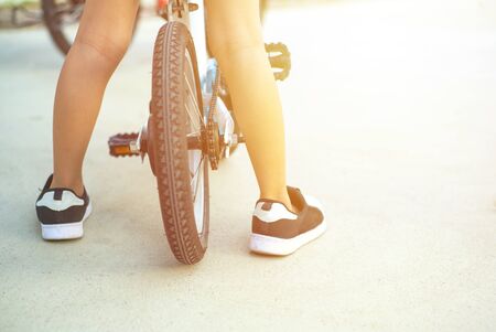 Closeup legs of boy stands over the small  bicycle during practicingの写真素材