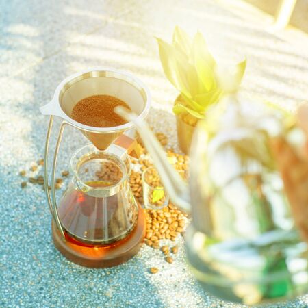 Top view of classic coffee dip set with blurred barista pouring the boiled water with classic jar in foregroundの写真素材