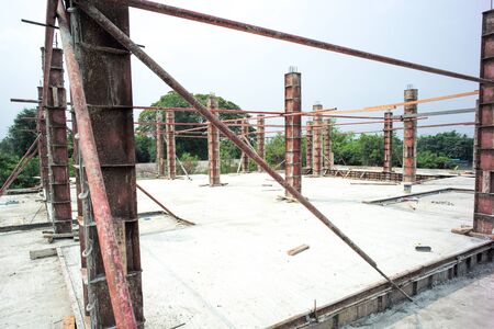 Perspective concrete columns in the steel model stand on the cement floor at the construction site with clear sky backgroundの写真素材