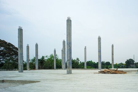 Perspective concrete columns stand on the cement floor at the construction site with clear sky backgroundの写真素材