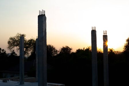 Closeup concrete columns reflect with the sunlight at the construction site with landscape and blue...