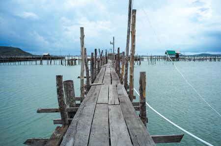 Native fisherman house and traditional fishing farm at the coast of sea with old wooden walkwayの写真素材