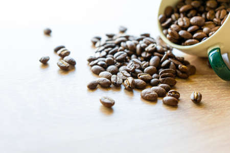 Closeup top view of many coffee beans in the ceramic mug with copy space for adding some textの写真素材