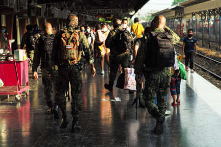 Songkhla, Thailand : April 11, 2021 - Rear view group of soldiers walking in the platform of Hat Yai train station for security with blurred crowded of people in backgroundのeditorial素材