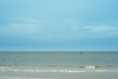 Traditional wooden boat floating in the sea for fishing with the horizontal line in backgroundの写真素材