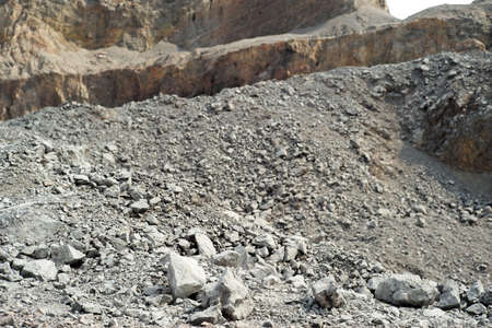 Closeup pile of crushed stone in the outdoor mine with blurred mountain in background