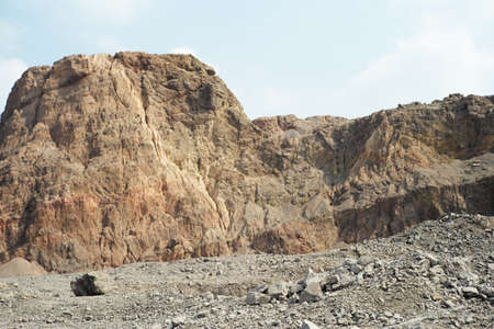 Closeup pile of crushed stone in the outdoor mine with blurred mountain in backgroundの写真素材