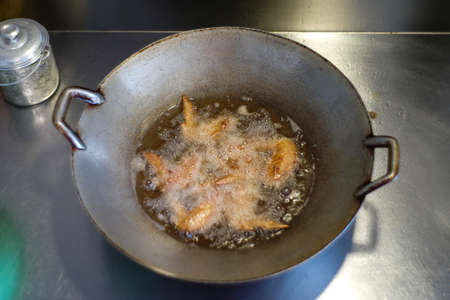 Top view many piece of chicken wings deep fried in the boiled vegetable oil.の写真素材