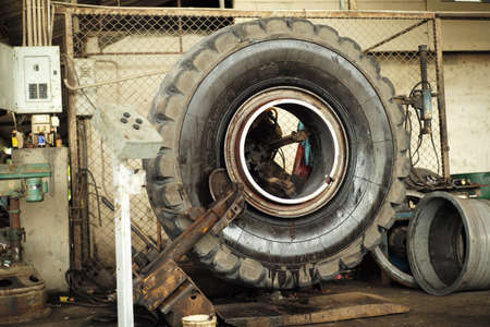 Closeup big tyre of truck under maintenance on the machine in the garageの写真素材