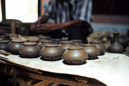 Group of clay jars in the production process with defocused old worker Group of clay jars in the production process with defocused old worker molding the clay work in background molding the clay work in backgroundの写真素材