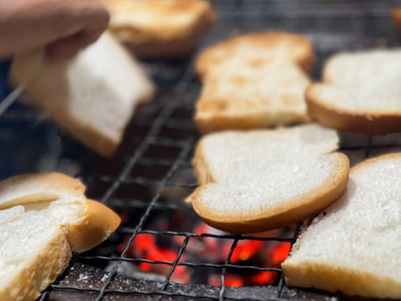 Selective focus on the dirty metal net with grilled sliced breads on the charcoal grillの写真素材