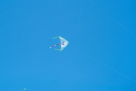 The flying kite in the air isolated on the blue sky backgroundの写真素材