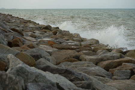 The strong wave hits the rock dam with seascape backgroundの写真素材