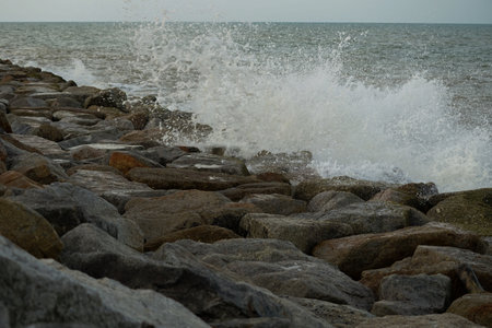 The strong wave hits the rock dam with seascape backgroundの写真素材