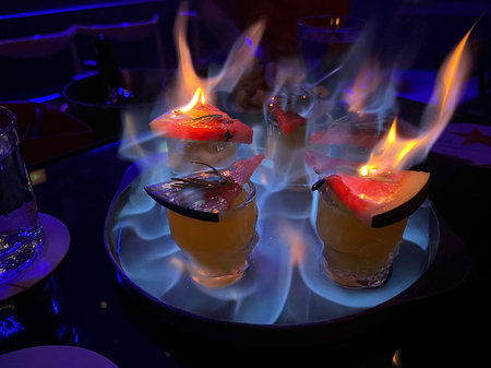 Many glasses of cocktail beverage decorated by the watermelon and flame of fire on the top of glasses. Party conceptの写真素材