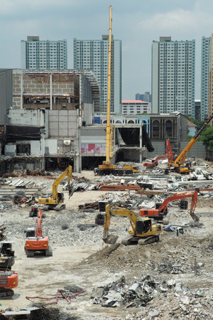 Many excavators working on the ground of the construction site while removing the salvage after the destruction of the buildingの写真素材