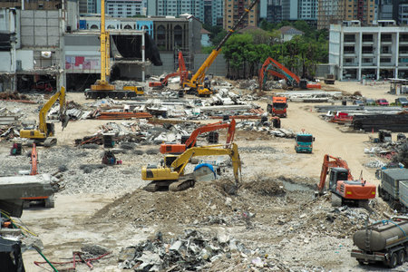 Many excavators working on the ground of the construction site while removing the salvage after the destruction of the buildingの写真素材