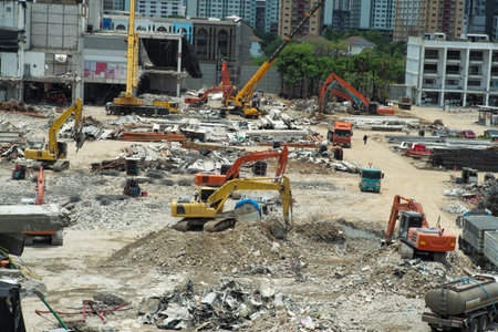 Many excavators working on the ground of the construction site while removing the salvage after the destruction of the buildingの写真素材