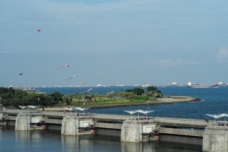 The concrete water gate in the sea with group of floating ships and clear sky in backgroundの写真素材