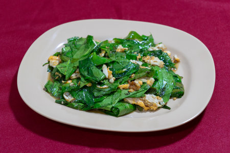 Closeup stir fired of vegetable with the egg.  Delicious Thai food.Stir-fried Malindjo Leaves with Eggの写真素材