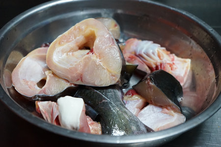 Closeup pieces of raw fish in the stainless bowl during the preparation for cookingの写真素材