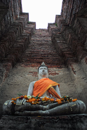 High angle view of Buddha statue with high red brick wall in backgroundの写真素材