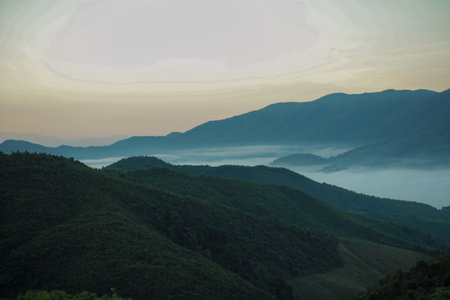 Panorama view layers of mountain with the fluffy white fog between the mountains and clear sky in backgroundの写真素材