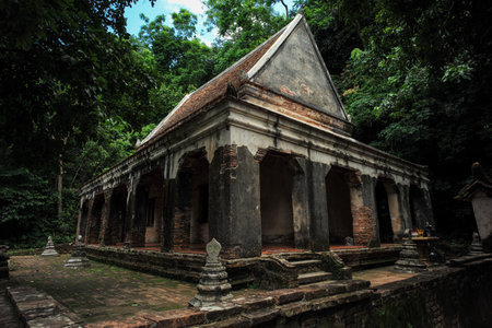 The old Buddhism temple located in the forest surrounded by the treesの写真素材