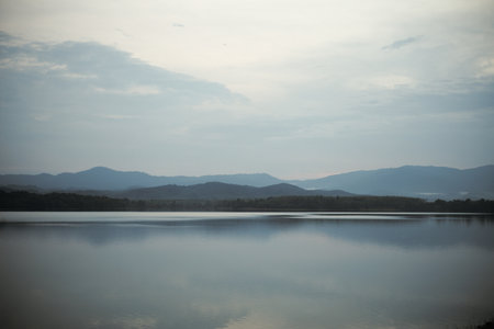 Panorama view of many layers of the mountains with the peaceful lagoon in foregroundの写真素材