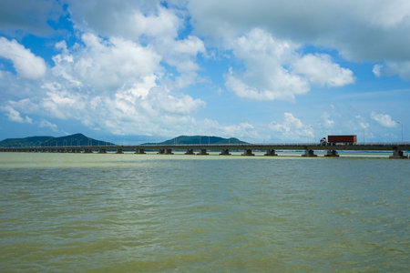 The straight concrete bridge cross over the ocean from the mainland to the island.の写真素材