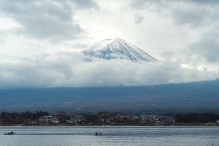 The oustanding summit of Fuji mountain isolated on the clear sky with lake in foreground