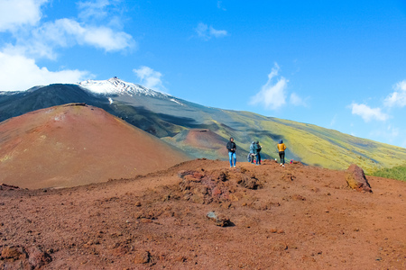 Mount Etna, Sicily, Italy - April 9th 2019: Tourists admiring the volcanic landscape around Etna volcano. Snow on the very top of the mountain. Popular tourist attraction.のeditorial素材