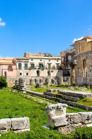 Stunning ruins of the Temple of Apollo in Ortigia Island, Syracuse, Sicily, Italy captured on a vertical photo with blue sky. Ancient Greek monument, archaeological site. Popular tourist spot.の写真素材