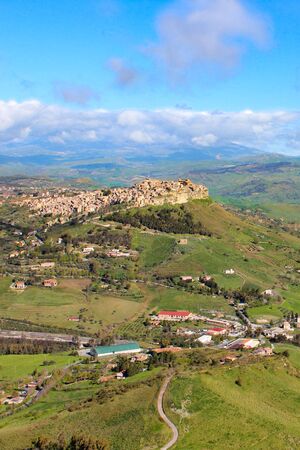 Beautiful Sicilian village Calascibetta photographed from nearby Enna with adjacent mountains and green landscape. Amazing landscapes in Italy. Italian travel destinations.の写真素材