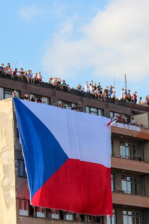 Prague, Czech Republic - June 23 2019: People on a roof of a building supporting protests against Prime Minister Babis and Minister of Justice on Letna, Letenska plan. Demonstration, czech flag.のeditorial素材