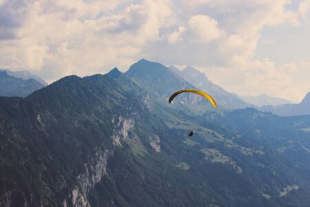 Paragliders over Swiss Alps in summer. Bad weather, risk, danger concept. Extreme sports, adventure...