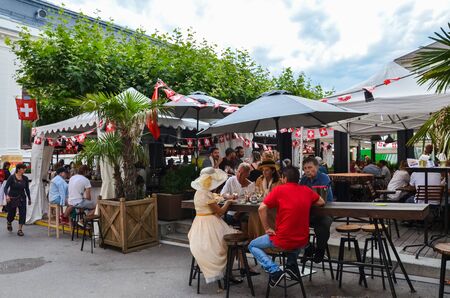 Vevey, Switzerland - Aug 1 2019: People celebrating Swiss National Day in outdoor restaurant. Celebration of the founding of the Swiss Confederacy. Independence day. Switzerland flags decoration.のeditorial素材