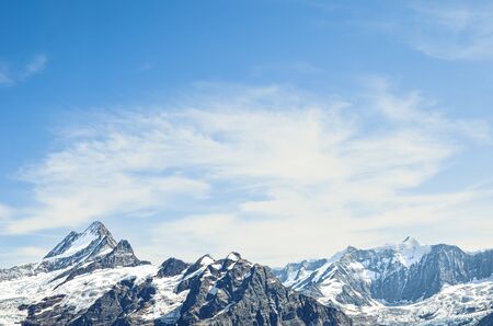 Alpine mountain peaks with blue sky and light clouds. Mountain climbing. Copy space, place for text....