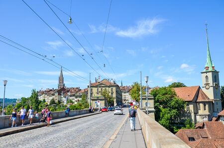 Bern, Switzerland - August 14, 2019: Historical Nydegg Bridge, Nydeggbrucke in German, in the historical center of the Swiss capital. Nydegg Church in background. People walking. Tourist attraction.のeditorial素材