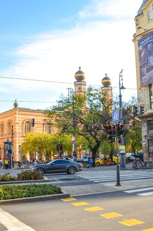 Budapest, Hungary - Nov 6, 2019: Road in the center of the Hungarian capital. Dohany Street Synagogue, the largest synagogue in Europe in the background. Zebra crossing and lights in the foreground.のeditorial素材