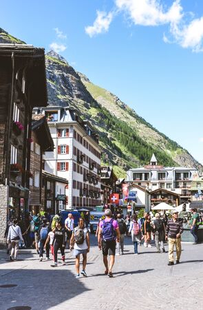 Zermatt, Switzerland - July 10, 2019: Street with tourists in beautiful Alpine village Zermatt in the summer season. The city center with people. Swiss Alps. Travel destinations.のeditorial素材