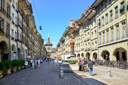 Bern, Switzerland - August 14, 2019: People walking in the old town of the Swiss capital. Famous Kramgasse with astronomical clock Zytglogge. Historical buildings, traditional fountains.のeditorial素材